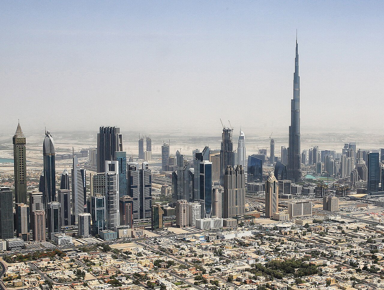 Helikopter vliegt boven de skyline van Dubai met de Burj Khalifa